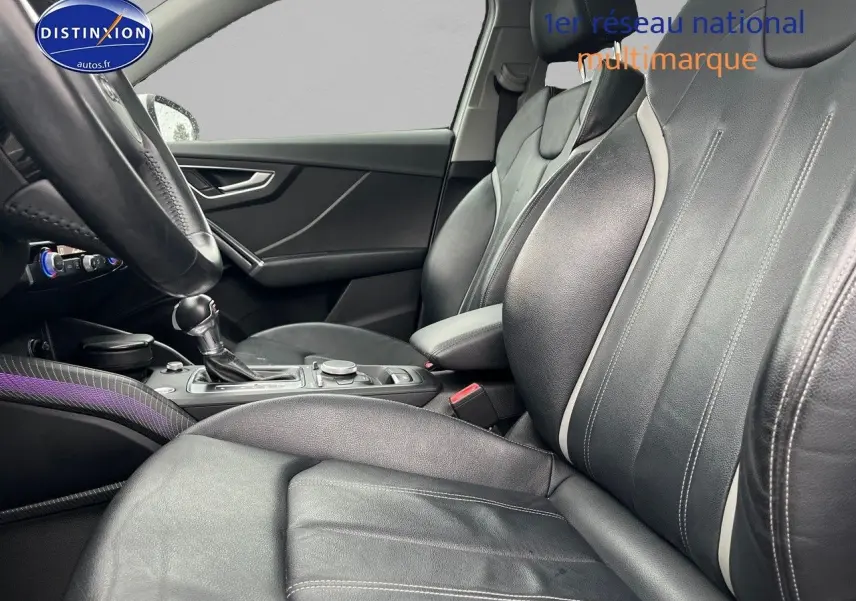 Vue intérieure côté conducteur de l'Audi Q2 2018 avec sièges cuir noir et console centrale visible.
