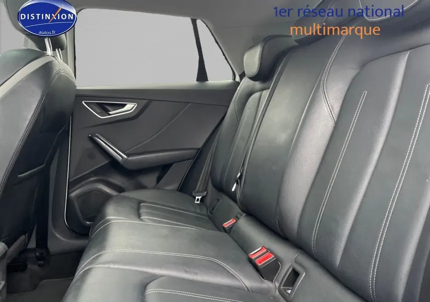 Vue intérieure du siège arrière en cuir noir avec surpiqûres blanches d'un Audi Q2 blanc, côté gauche visible.