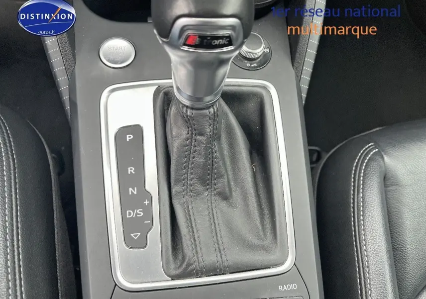 Vue rapprochée de la console centrale de l’Audi Q2 blanc Ibis, mettant en valeur le levier de vitesse S tronic en cuir noir.