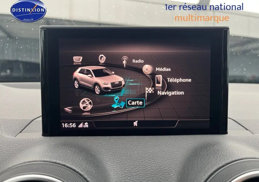 Écran central montrant l'interface multimédia avec une image 3D de l'Audi Q2 blanc Ibis en vue latérale.