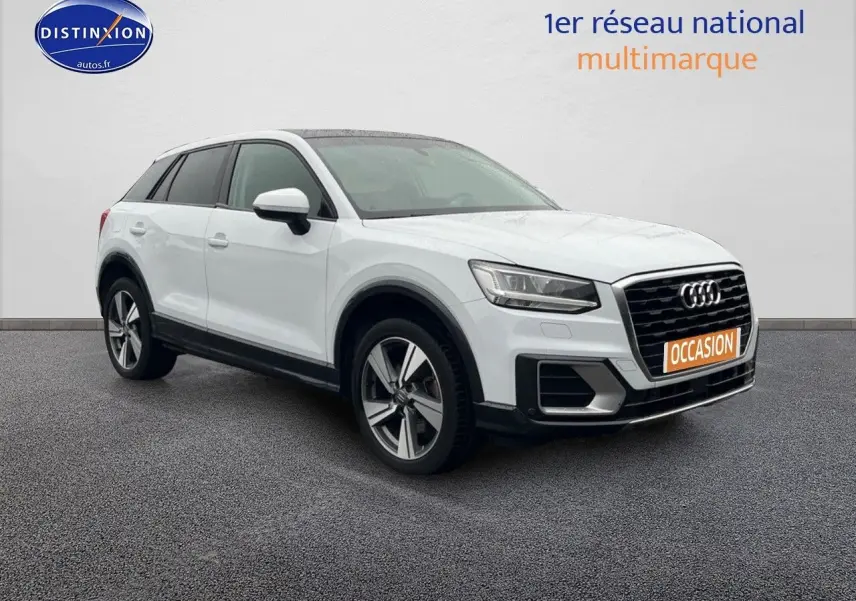 Audi Q2 blanc Ibis vu en 3/4 avant droit, avec jantes alliage 18 pouces et toit ouvrant électrique.
