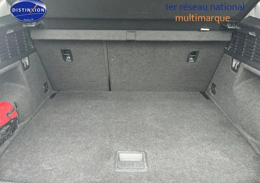 Coffre ouvert vu de face de l'Audi Q2 blanc Ibis, montrant un espace de chargement propre et spacieux.