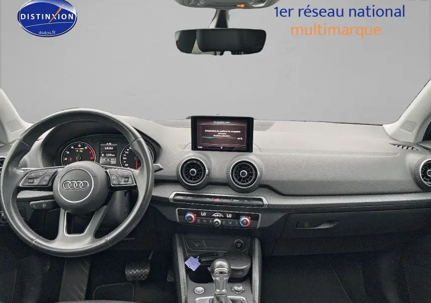 Vue intérieure du tableau de bord et volant cuir noir de l'Audi Q2 2018 avec écran central et commandes climatisation.