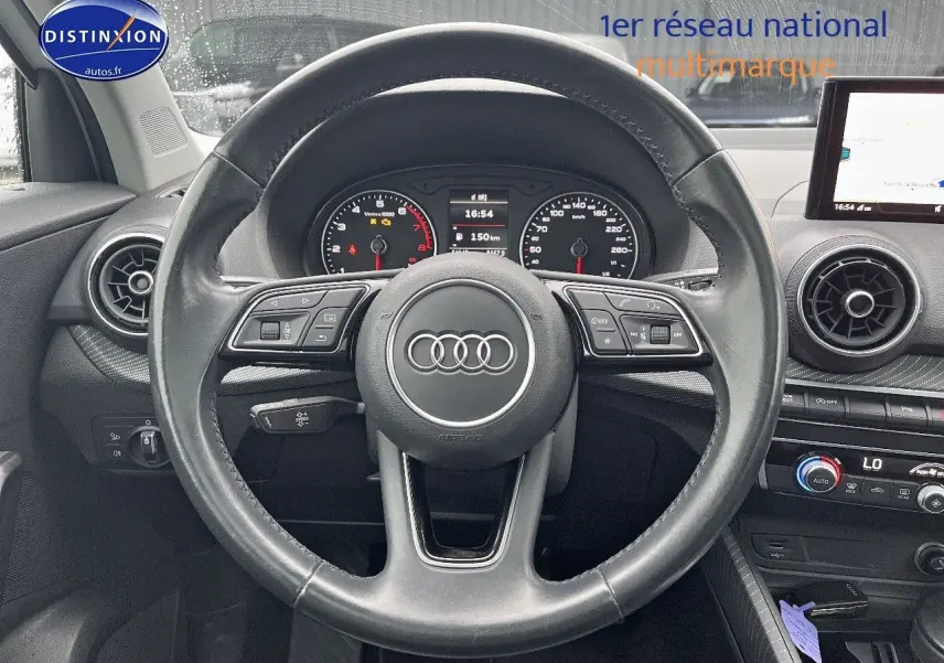 Vue centrée sur le volant cuir multifonction noir de l'Audi Q2 2018 avec tableau de bord et écran multimédia.