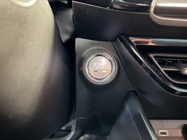 Gros plan sur le bouton Start/Stop du tableau de bord noir de la MG3 Cosmic Silver, version hybride Luxury.