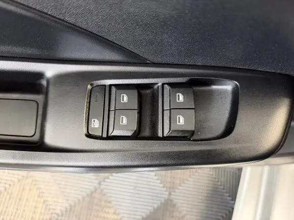 Gros plan sur les commandes des vitres électriques côté conducteur du MG3 Cosmic Silver, intérieur noir.