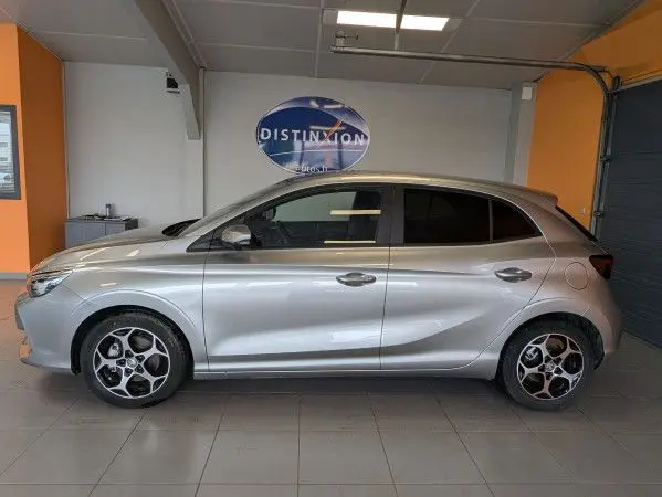 Vue latérale droite d'une MG3 Cosmic Silver avec jantes alliage 16 pouces et vitres surteintées dans un garage.
