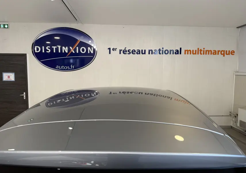 Vue plongeante sur le toit Cosmic Silver brillant du MG3 2026, reflétant le logo Distinxion en intérieur showroom.