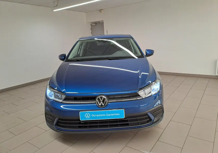 Volkswagen Polo 1.0 TSI 95 VW Edition bleu récif vue de face avec phares LED allumés en intérieur.