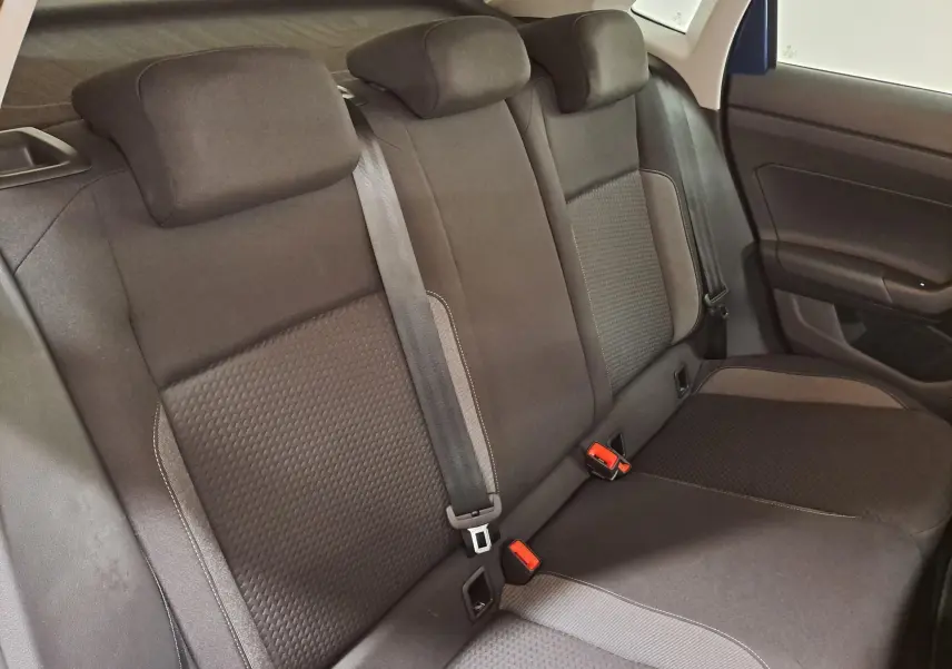 Vue intérieure de la banquette arrière de la Volkswagen Polo 2025 avec sièges noirs et ceintures de sécurité visibles.
