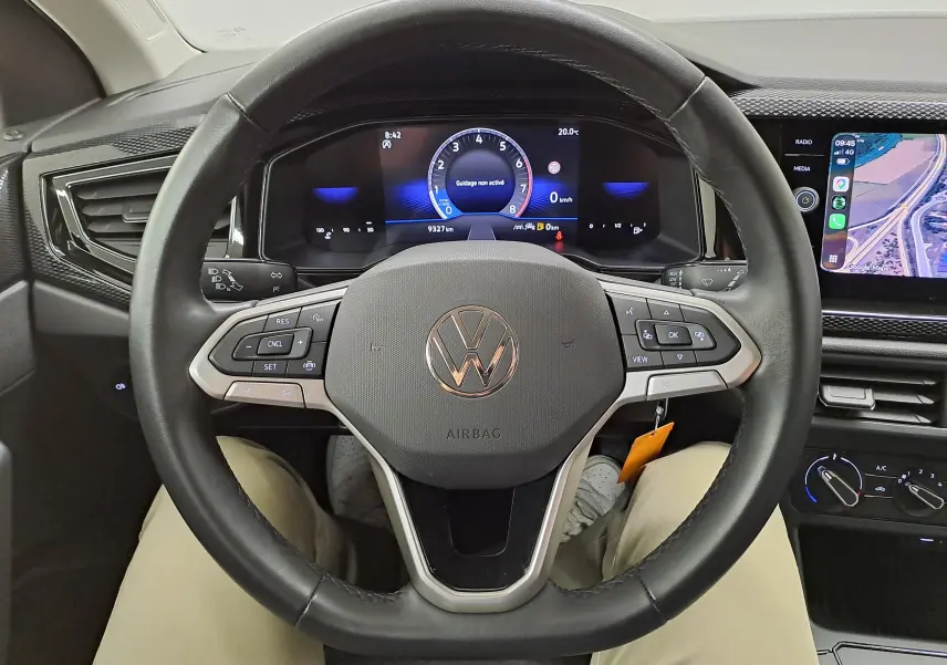 Vue rapprochée du volant cuir multifonctions noir et du tableau de bord digital d'une Volkswagen Polo 2025.
