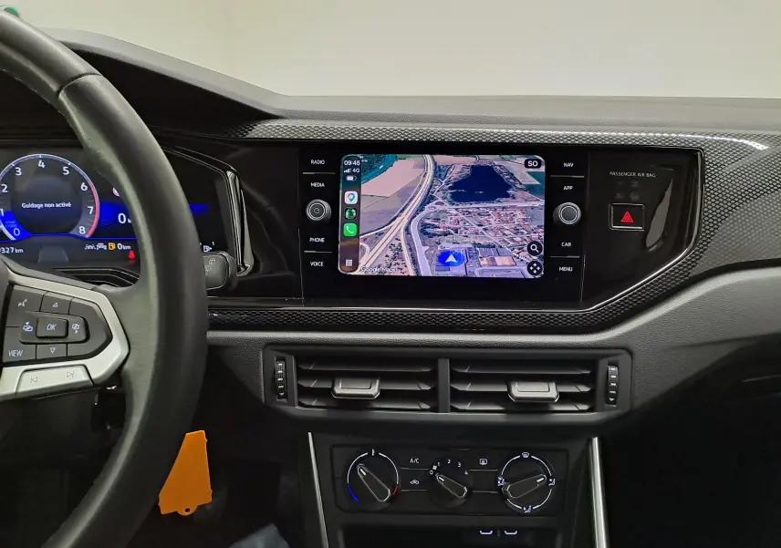 Tableau de bord noir de Volkswagen Polo 2025, vue centrée sur l’écran tactile de navigation et volant partiel à gauche.