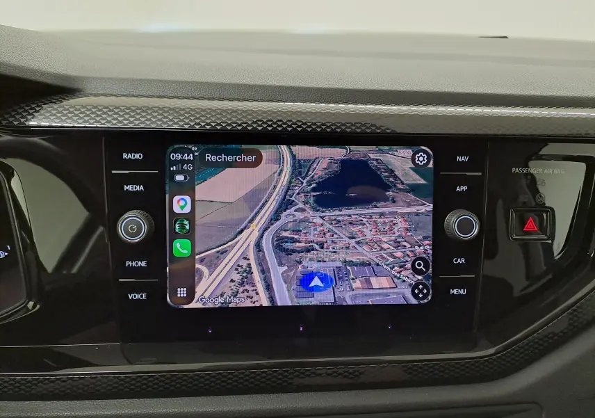 Écran tactile central de la Volkswagen Polo 2025 affichant la navigation Google Maps avec commandes autour et finition noire brillante.