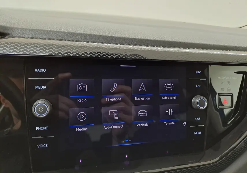 Écran tactile central du système infotainment de la Volkswagen Polo 2025 avec commandes et finition noire brillante.