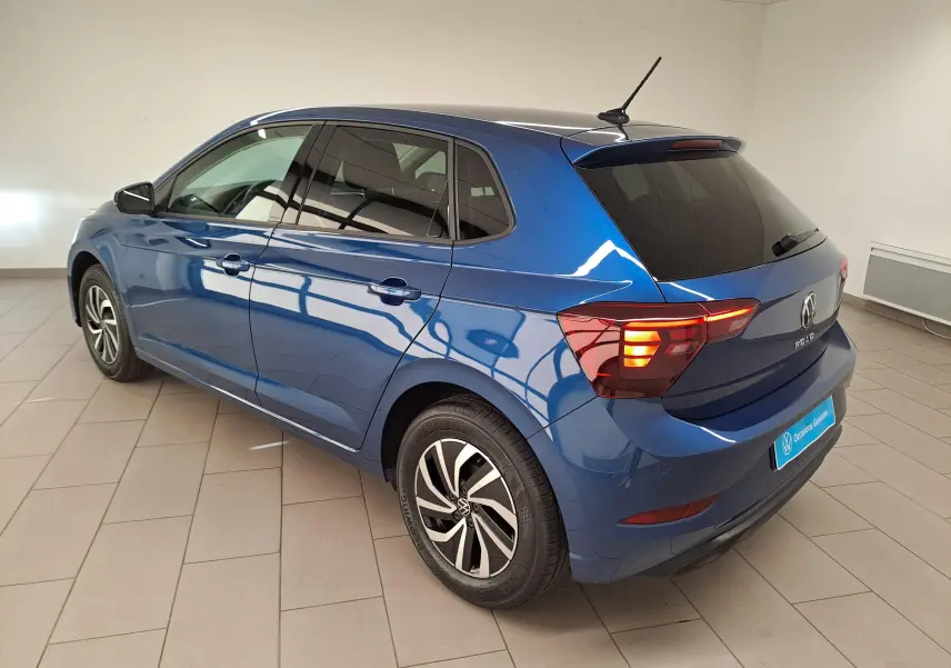Vue 3/4 arrière droite d'une Volkswagen Polo Bleu Récif avec jantes alliage et vitres arrière surteintées.