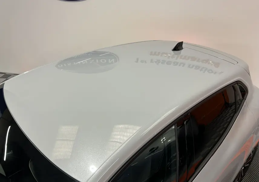 Vue plongeante sur le toit gris métal brillant d'une Renault Clio V hybride, avec antenne requin noire visible.