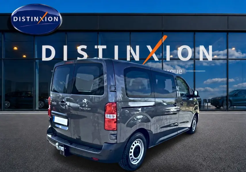 Vue 3/4 arrière droite du Peugeot Expert Fourgon gris 2024 avec porte latérale coulissante et attelage visible.