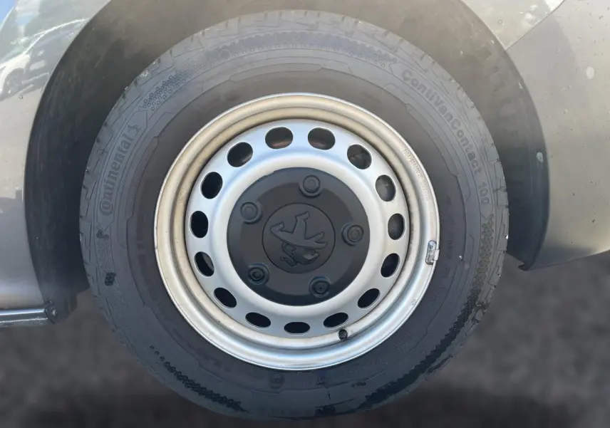 Gros plan sur la roue avant droite grise du Peugeot Expert Fourgon avec jante acier et logo Peugeot central.