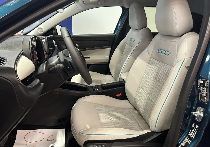 Vue intérieure côté conducteur de la FIAT 600 Hybrid 2024 bleu, sièges cuir beige avec logo 600 brodé bleu.