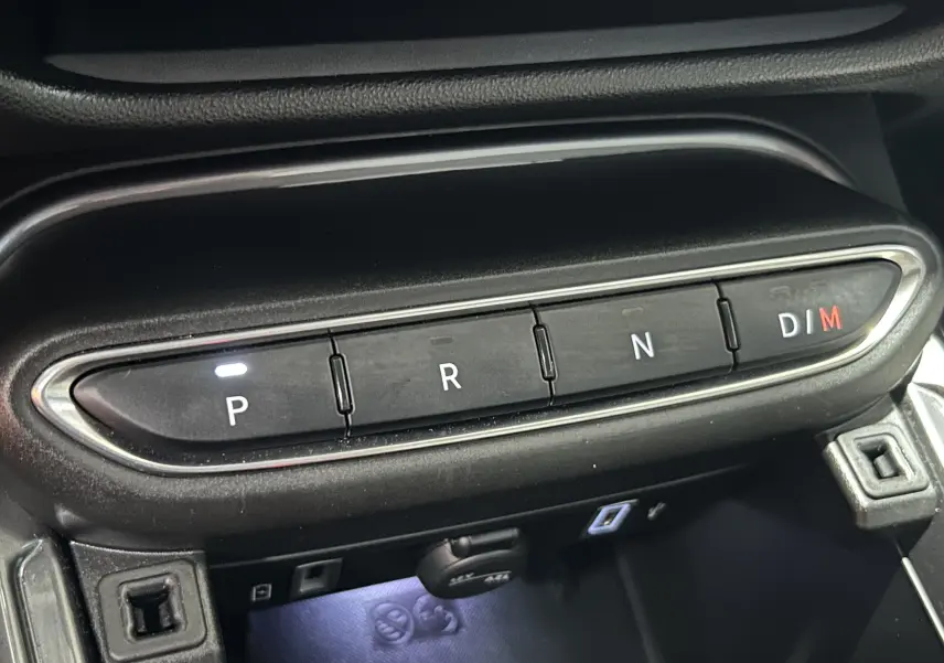 Gros plan sur la commande de boîte automatique avec boutons P, R, N, D/M éclairés dans l'habitacle d'une FIAT 600 bleu.