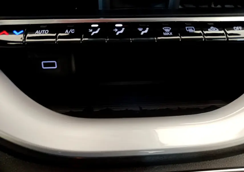 Gros plan sur les commandes de climatisation avec éclairage blanc, dans l'habitacle d'une FIAT 500 blanche Icône 2022 électrique.