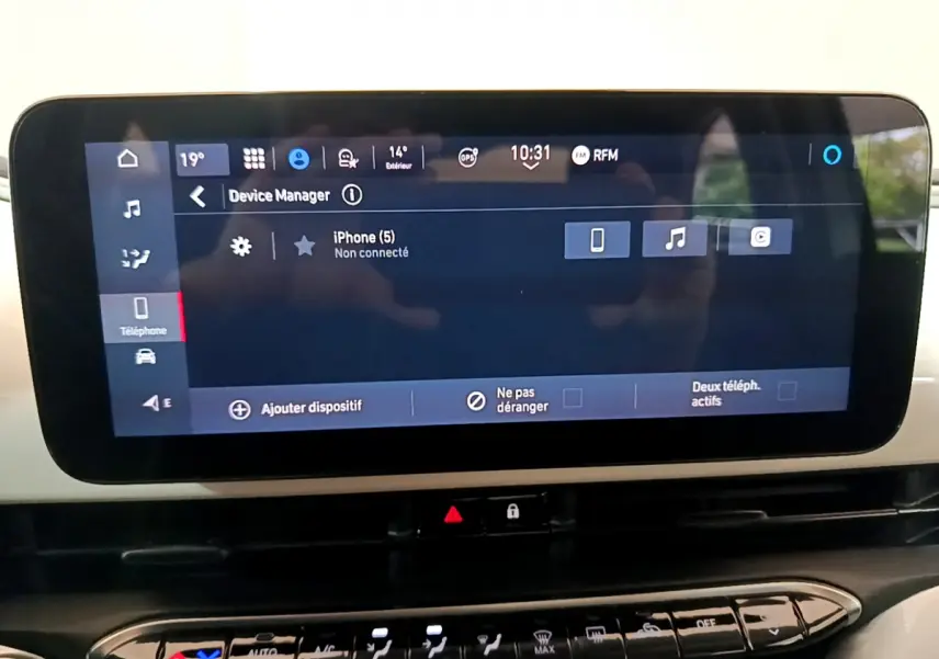 Écran tactile central de la Fiat 500 électrique blanche, affichant le gestionnaire de périphériques en intérieur.