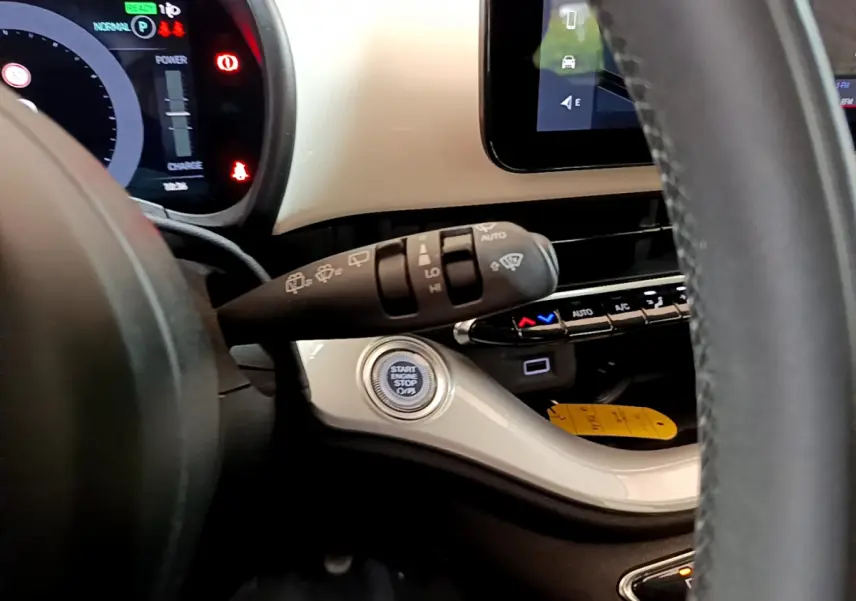 Détail du tableau de bord blanc et volant de la Fiat 500 électrique 42kWh Icône, avec bouton démarrage et commandes essuie-glaces.