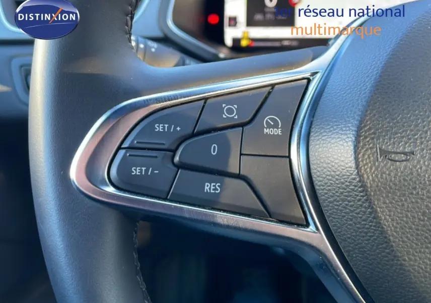 Gros plan sur les commandes au volant noir du Renault Captur 2025, boutons de régulateur de vitesse visibles.