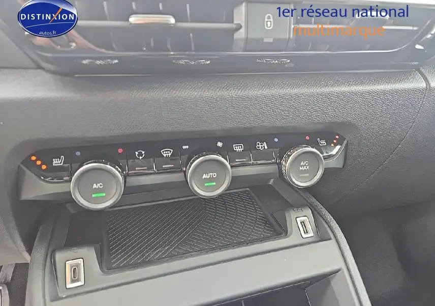 Vue rapprochée de la console centrale noire de la Citroën C4 Bleu Eclipse 2025 avec commandes climatisation et prises USB visibles.