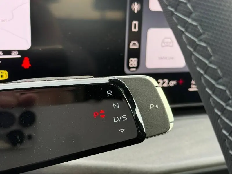 Gros plan sur le levier de vitesses noir brillant de l’Audi Q3 2.0 TDI 150ch S line, avec affichage digital en rouge.