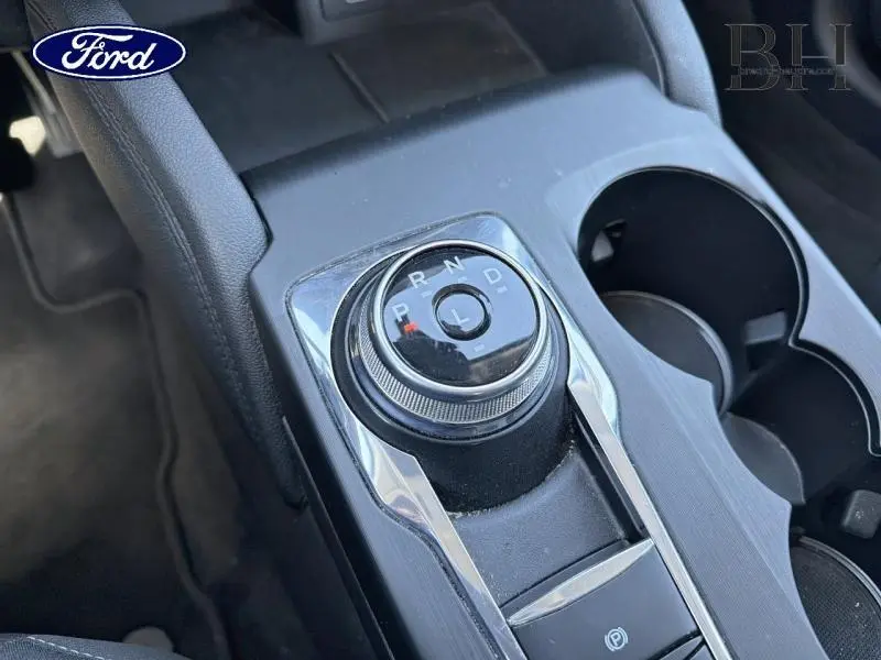 Gros plan sur la molette de sélection de la boîte automatique noire dans la console centrale du Ford Kuga 2023.