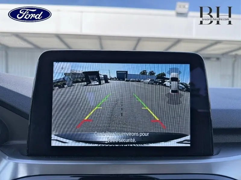 Écran tactile intérieur montrant la caméra de recul du Ford Kuga 2023, vue arrière avec lignes de guidage colorées.