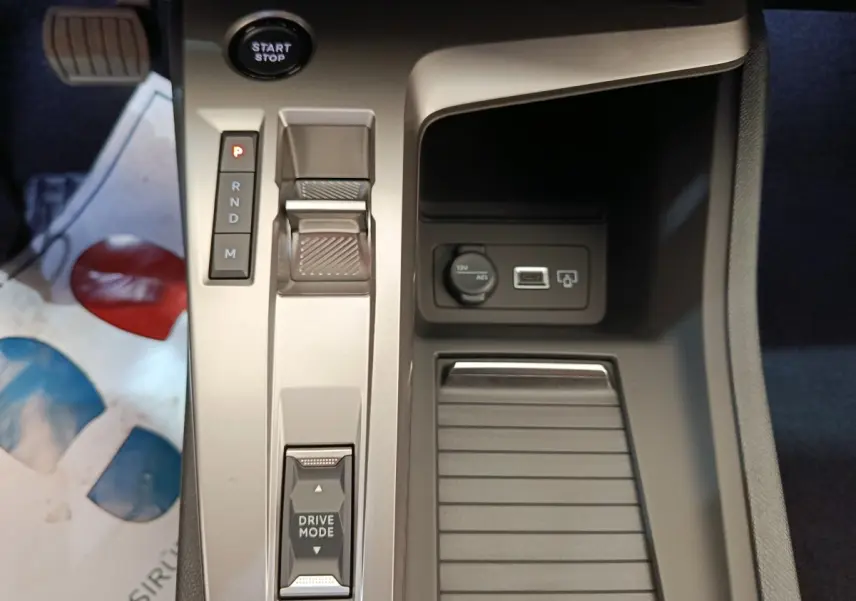 Vue rapprochée de la console centrale de la Peugeot 308 BlueHDi 130, avec sélecteur de boîte auto et prise 12V visible.