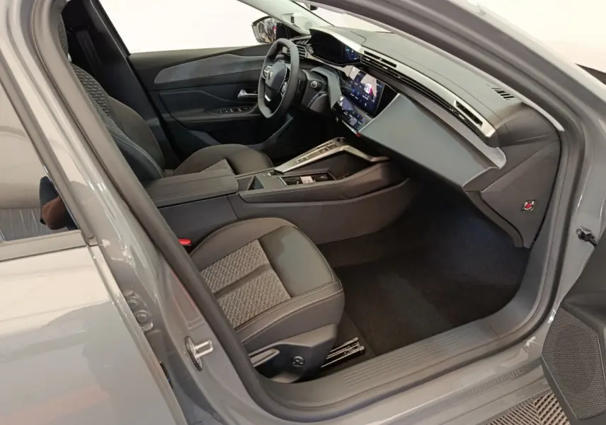 Vue intérieure côté conducteur de la Peugeot 308 gris foncé 2026, avec volant cuir multifonctions et écran tactile central.