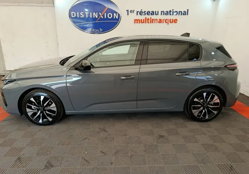 Peugeot 308 BlueHDi 130 gris foncé vue de profil côté gauche, jantes alliage noires et grises visibles.
