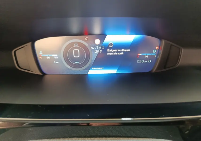 Affichage numérique du combiné instruments de la Peugeot 308 gris foncé, avec indication vitesse et alertes.