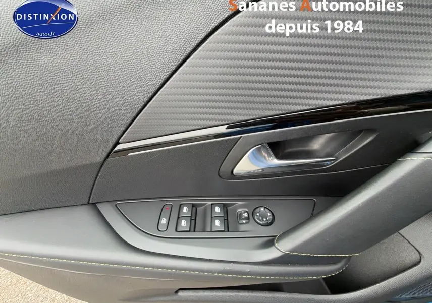 Gros plan sur la porte côté conducteur de la Peugeot 208 GT Line 2020 avec commandes des vitres et poignée noire.
