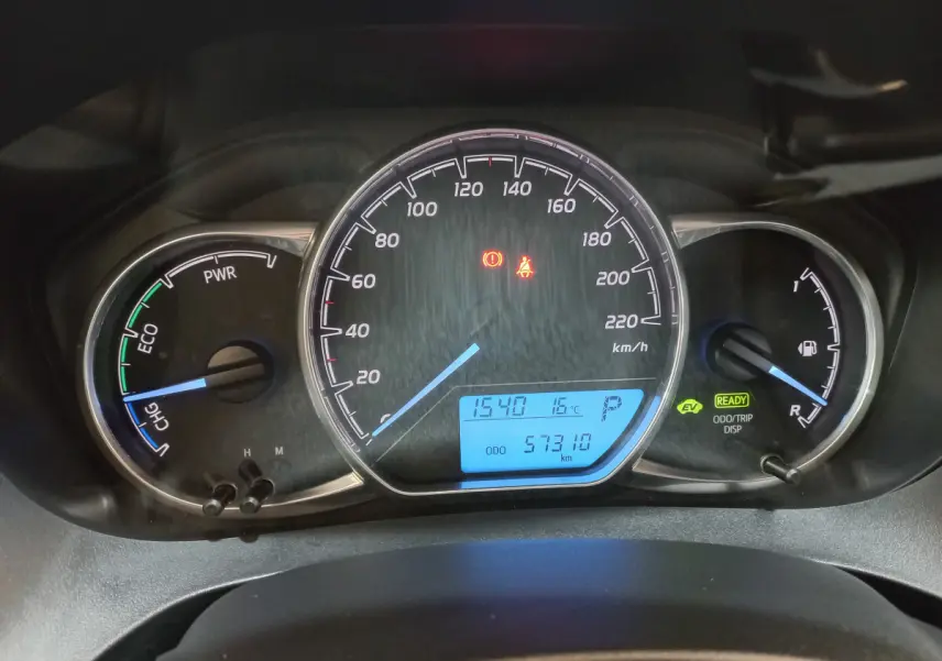 Tableau de bord de Toyota Yaris hybride 2019, affichage digital bleu avec compte-tours, vitesse et jauge carburant.