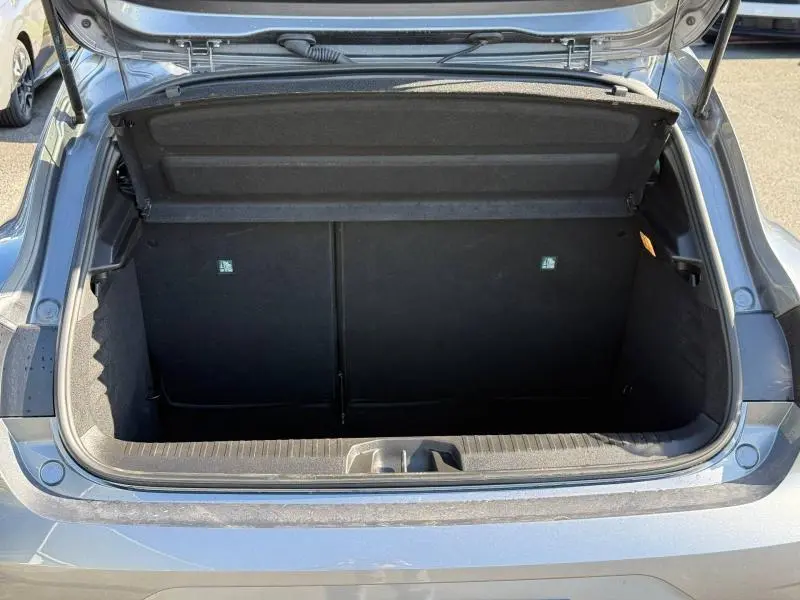 Coffre ouvert vu de l'arrière d'une Renault Clio 1.0 TCe 90ch Evolution gris schiste, montrant l'espace de chargement vide.