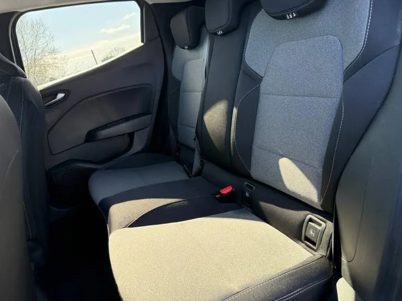 Vue côté gauche de la banquette arrière en tissu gris et noir de la Renault Clio 2025, avec ceintures et appuie-têtes visibles.