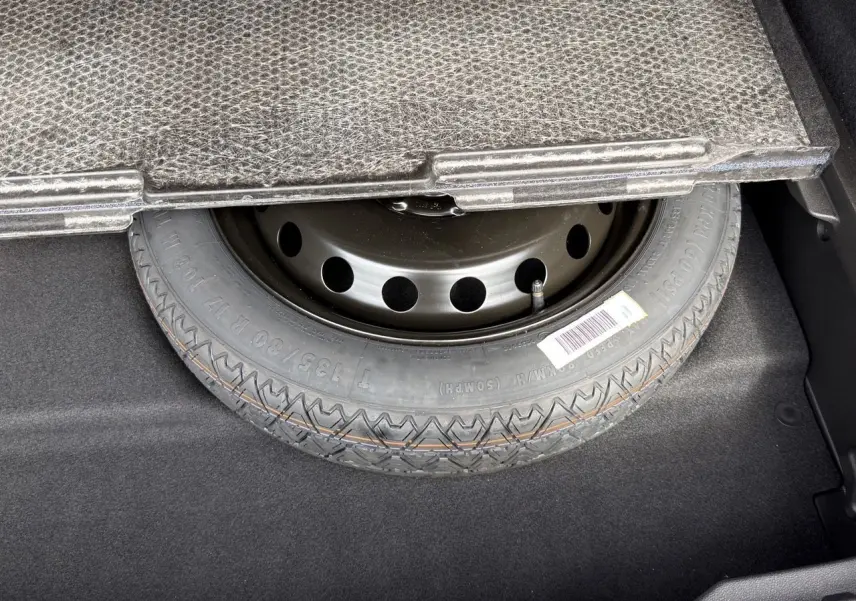 Gros plan sur la roue de secours sous le plancher du coffre d’une Renault Symbioz E-Tech Full Hybrid 2025.