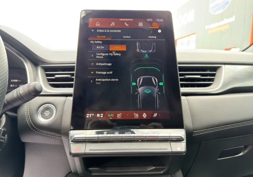 Vue rapprochée de l’écran tactile central du Renault Symbioz 2025, affichant les aides à la conduite, dans un intérieur noir.