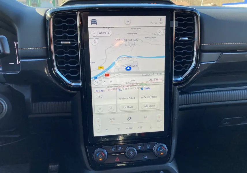 Vue rapprochée de l’écran tactile central du Ford Ranger 2025 avec navigation et commandes climatisation visibles.