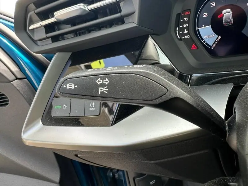 Gros plan sur la commande de clignotants et feux dans l'habitacle bleu Atoll métallisé de l'Audi A3 Sportback 35 TFSI 2022.