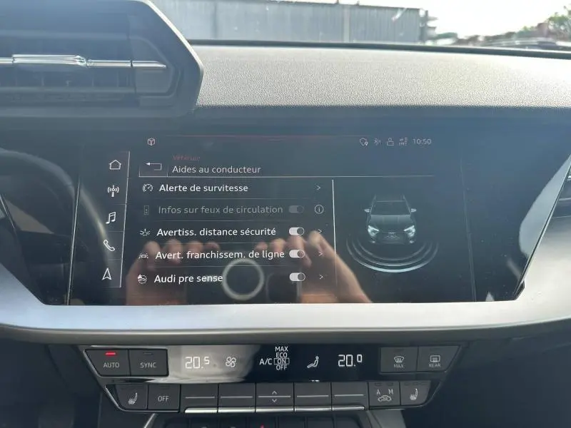 Vue rapprochée de l’écran tactile central de l’Audi A3 Sportback 35 TFSI, affichant les aides à la conduite.