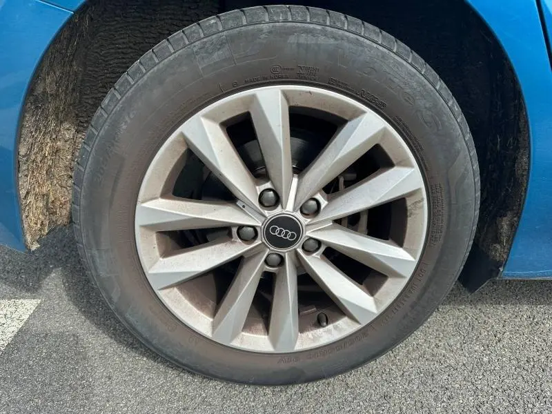 Gros plan sur la jante alu grise de l'Audi A3 Sportback bleu Atoll métallisé, côté droit, avec pneu visible.