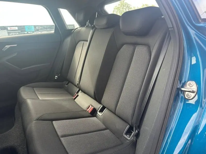 Vue intérieure côté droit sur la banquette arrière noire de l'Audi A3 Sportback 35 TFSI bleu Atoll métallisé.