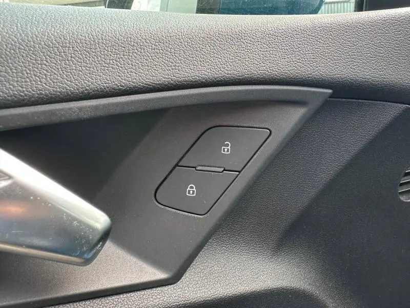 Détail intérieur côté conducteur de la porte d’une Audi A3 Sportback bleu Atoll, boutons de verrouillage centralisé.