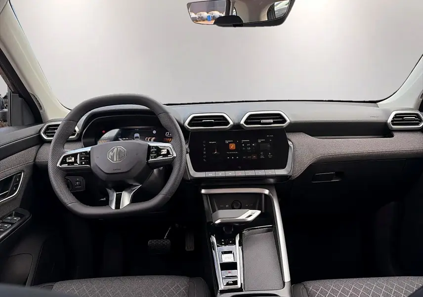 Vue intérieure avant du MG Motor ZS 1.5 hybrid 197, tableau de bord gris avec écran tactile et volant multifonction.
