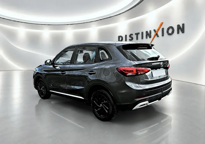 Vue 3/4 arrière droite du MG ZS 1.5 hybrid Camden grey, avec jantes noires et becquet arrière distinctif.